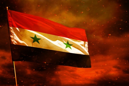 Fluttering Syrian Arab Republic flag on crimson red sky with smoke pillars background. Syrian Arab Republic problems concept.の写真素材