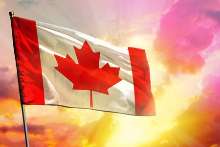 Fluttering Canada flag on beautiful colorful sunset or sunrise background. Canada success and happiness concept.の写真素材