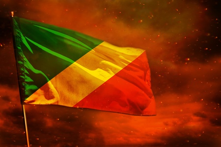 Fluttering Congo flag on crimson red sky with smoke pillars background. Congo problems concept.の写真素材