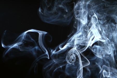 marvellous flowing contrast blue smoke on heavy black background.の写真素材
