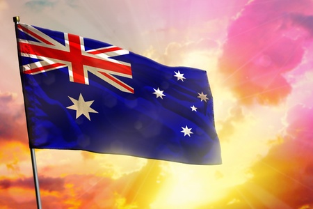 Fluttering Australia flag on beautiful colorful sunset or sunrise background. Australia success and happiness concept.の写真素材