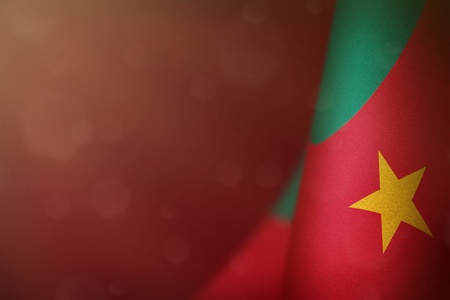 Cameroon hanging flag for honour of veterans day or memorial day on red dark velvet background. Cameroon glory to the heroes of war concept.の写真素材