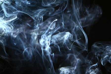 beautiful swirl glowing bright smoke against black background.の写真素材