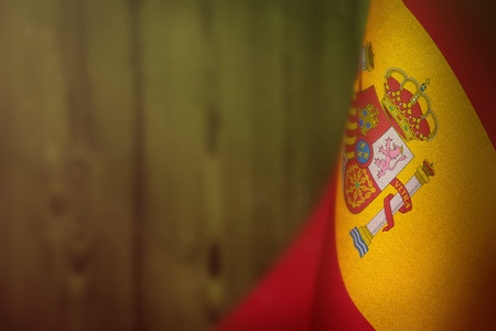 Spain hanging flag for honour of veterans day or memorial day on lime blurred natural wood wall background. Spain glory to the heroes of war concept.の写真素材