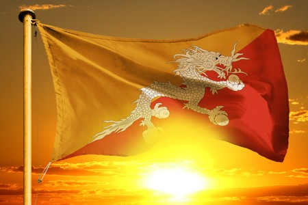 Bhutan flag weaving on the beautiful orange sunset backgroundの写真素材