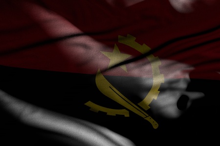 pretty photo of dark Angola flag with folds lying in shadows with light spots on it - any occasion flag 3d illustrationの写真素材