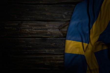 nice dark illustration of Sweden flag with big folds on old wood with free place for your content - any holiday flag 3d illustrationの写真素材
