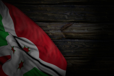 pretty dark illustration of Burundi flag with large folds on old wood with empty place for text - any holiday flag 3d illustrationの写真素材
