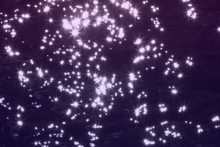 wonderful purple glossy sparks on dark water surface texture - abstract photo backgroundの写真素材