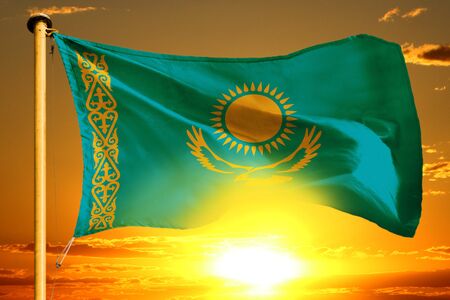Kazakhstan flag weaving on the beautiful orange sunset backgroundの写真素材