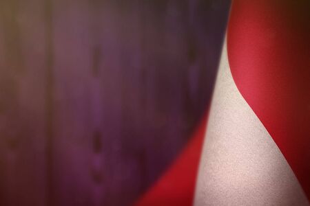 Monaco hanging flag for honour of veterans day or memorial day on purple blurred natural wood wall...