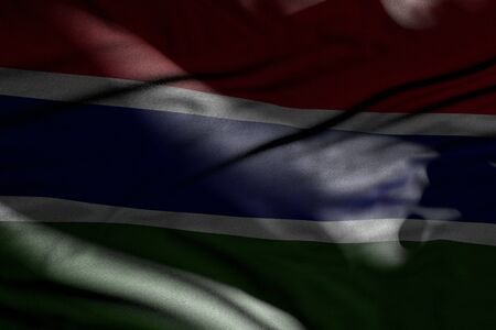 wonderful national holiday flag 3d illustration - illustration of dark Gambia flag with folds lying in shadows with light spots on itの写真素材