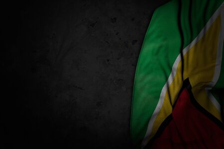pretty dark picture of Guyana flag with large folds on black stone with empty space for content - any occasion flag 3d illustrationの写真素材