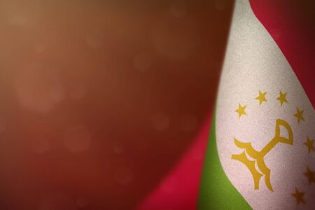 Tajikistan hanging flag for honour of veterans day or memorial day on red dark velvet background. Tajikistan glory to the heroes of war concept.の写真素材