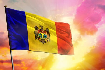 Fluttering Moldova flag on beautiful colorful sunset or sunrise background. Moldova success and happiness concept.の写真素材
