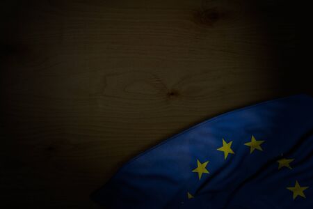 cute dark photo of European Union flag with big folds on dark wood with empty place for content - any holiday flag 3d illustrationの写真素材