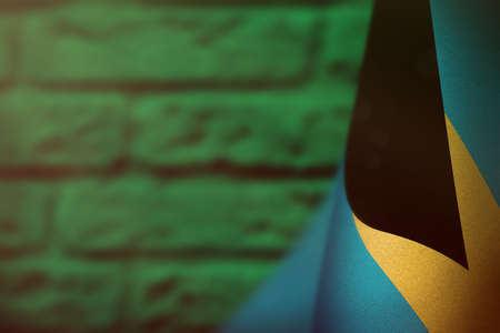 Bahamas hanging flag for honour of veterans day or memorial day on teal, sea-green blurred painted brick wall background. Bahamas glory to the heroes of war concept.の写真素材