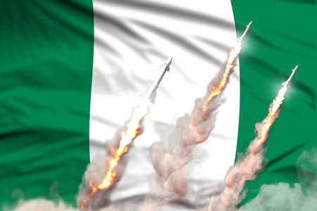Nigeria nuclear warhead launch - modern strategic nuclear rocket weapons concept on flag fabric background, military industrial 3D illustration with flagの写真素材