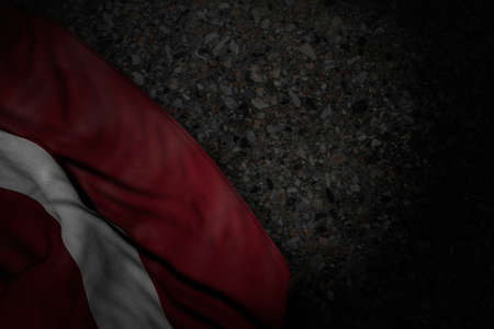 cute dark picture of Latvia flag with large folds on dark asphalt with free place for text - any holiday flag 3d illustrationの写真素材