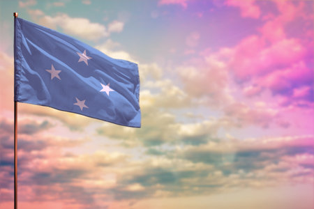 Fluttering Micronesia flag mockup with the place for your text on colorful cloudy sky background.の写真素材
