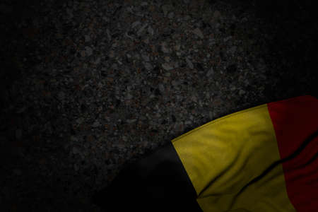 cute dark picture of Belgium flag with large folds on dark asphalt with empty place for text - any feast flag 3d illustrationの写真素材