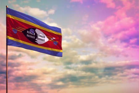 Fluttering Swaziland flag mockup with the place for your text on colorful cloudy sky background.