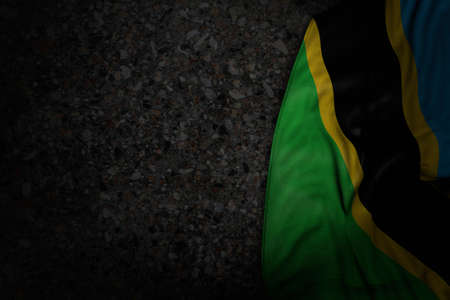 beautiful national holiday flag 3d illustration - dark image of Tanzania flag with big folds on dark...