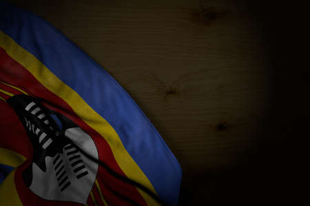 cute dark picture of Swaziland flag with large folds on dark wood with empty space for text - any celebration flag 3d illustrationの写真素材