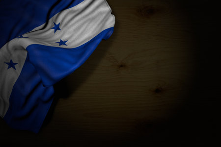 beautiful dark photo of Honduras flag with big folds on dark wood with free place for content - any occasion flag 3d illustrationの写真素材