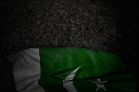 nice labor day flag 3d illustration - dark image of Pakistan flag with big folds on dark asphalt with empty place for your textの写真素材