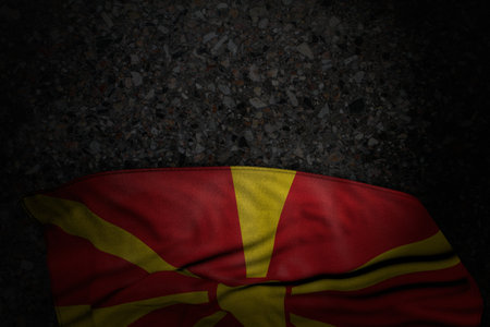 wonderful celebration flag 3d illustration - dark picture of Macedonia flag with large folds on dark asphalt with empty space for your textの写真素材
