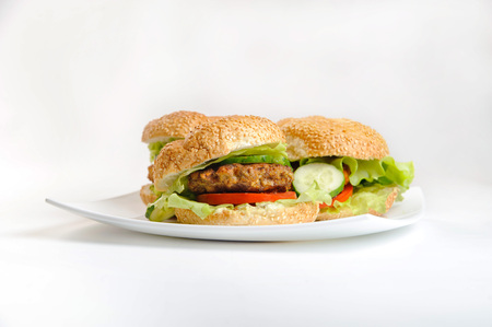 three hamburgers on white isolated plateの写真素材