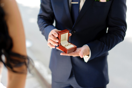 groom with box of engagement rings jewelry and surpriseの写真素材