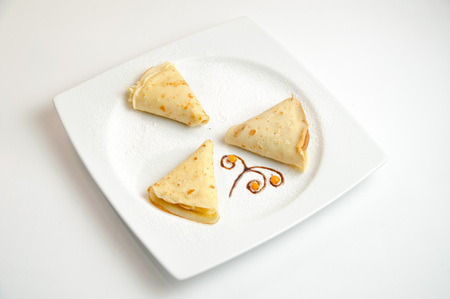 three pancakes on white isolated plateの写真素材