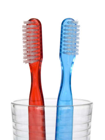 Two toothbrushes in a glass over white background.の写真素材