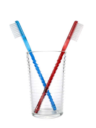 Two toothbrushes in a glass over white background.の写真素材
