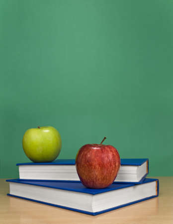 A blank chalkboard with apples over books.の写真素材