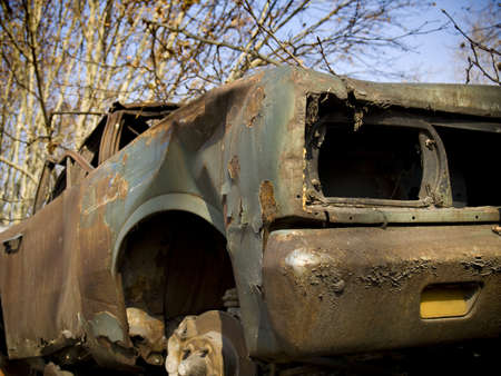 An old, broken and rusty abandoned car.