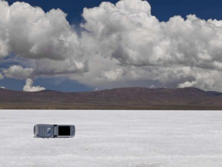 A cell phone abandoned on a salt field. Mountains on the background.の写真素材