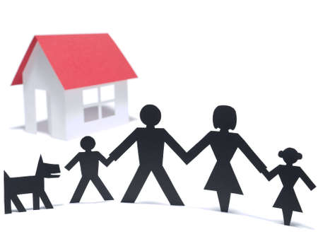 A paper family is holding hands beside their new paper house. Even the paper dog is there.の写真素材