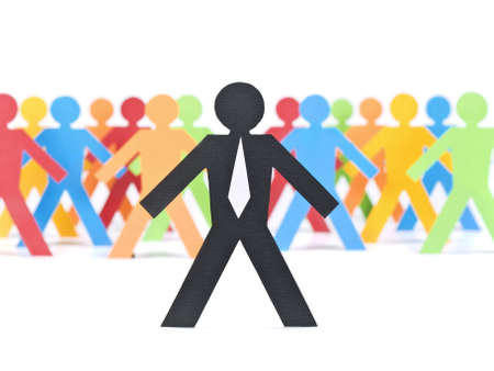 A paper businessman stands in front of a multicolored crew.の写真素材