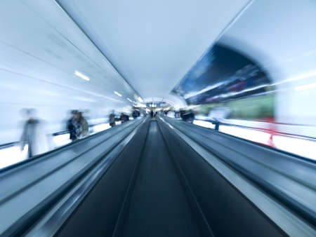 Futuristic image. Blurred people on the walkway tunnel. Empty center lane.の写真素材