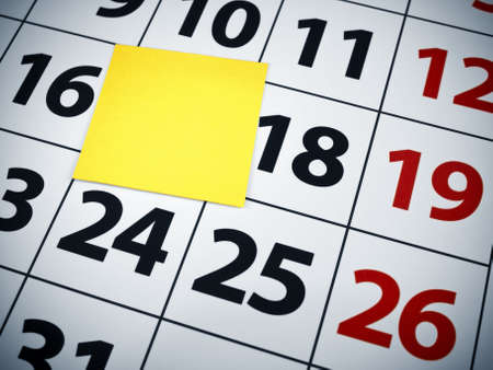 Close up of a blank sticky note on a calendar.の写真素材
