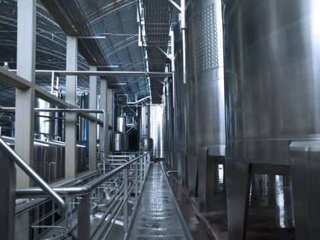 Stainless steel wine vats in a row inside the winery.の写真素材