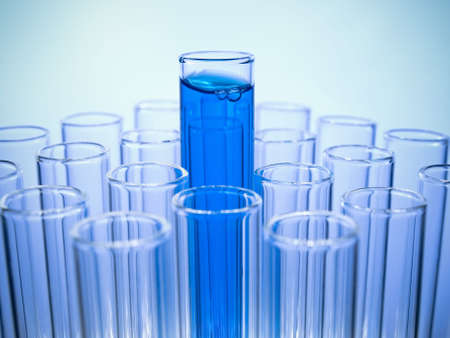A test tube filled with blue liquid coming out of many empty test tubes.の写真素材