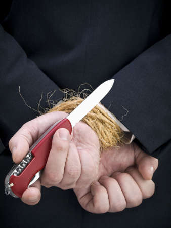 Closeup on a businessman's hands trying to set himself free.の写真素材