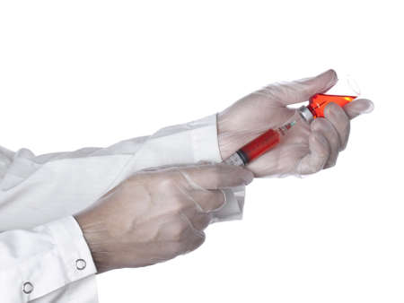 A doctor is taking a dose of a red medicine out of the vial.の写真素材