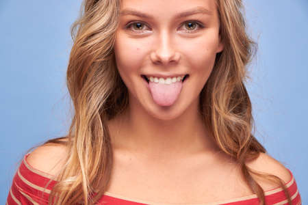 Close up photo of attractive funky carefree girl stick tongue out of mouth playful girls in red...
