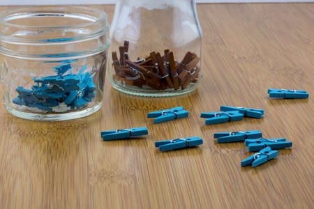 Tiny colorful pins in glass jars in macro with wooden backgroundの写真素材