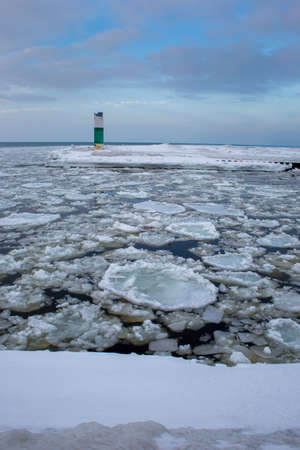Icebergs drifting in icy water with lighthouse in backgroundの写真素材